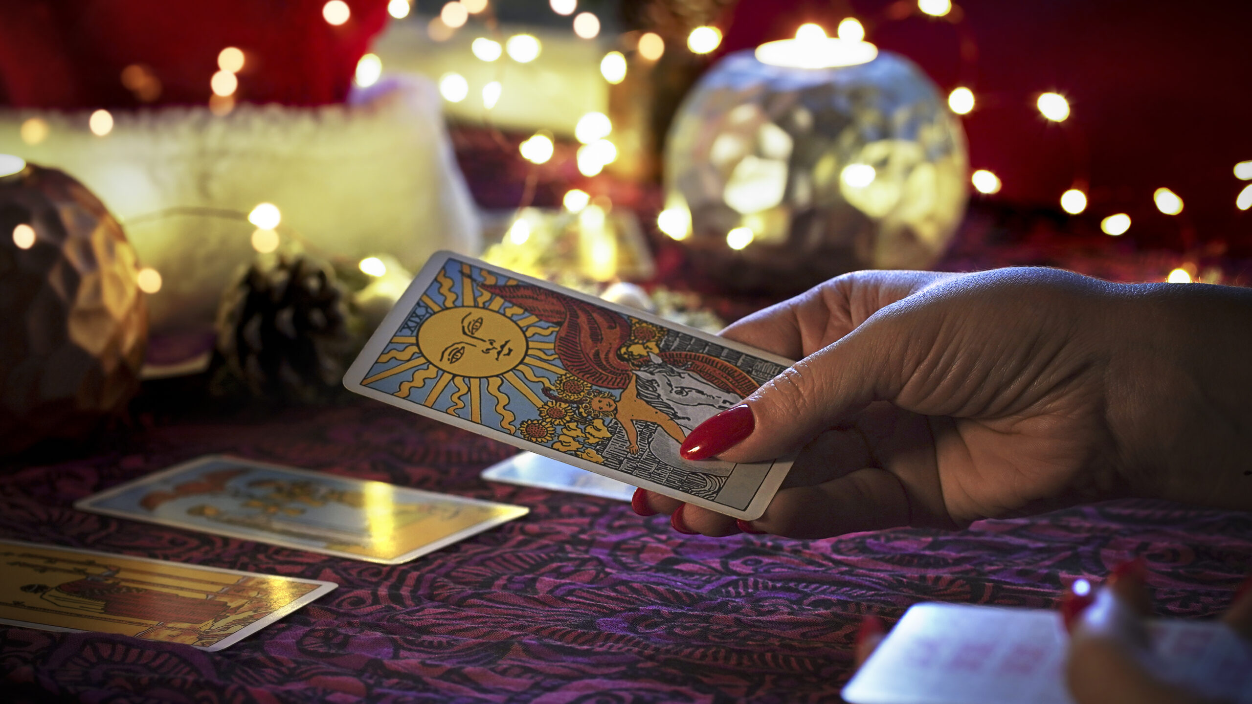 blurred-tarot-cards-table-near-burning-candles-fortune-teller-reading-christmas-decoration
